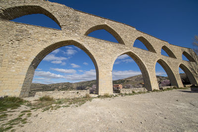 Low angle view of arch bridge against sky