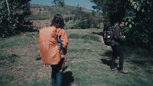 Rear view of people walking on land