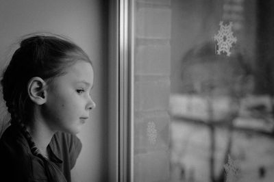 Portrait of girl looking through window