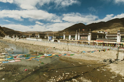 Scenic view of beach by buildings against sky