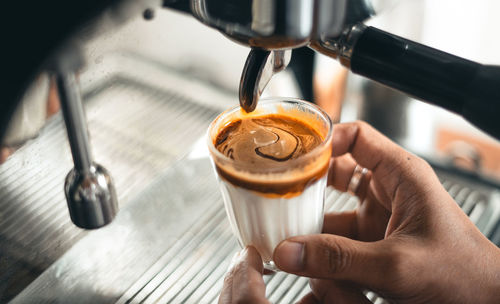 Cropped image of hand holding coffee cup