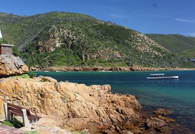 Seaside in knysna, part heads - a ship passing by the cliffs at the seaside