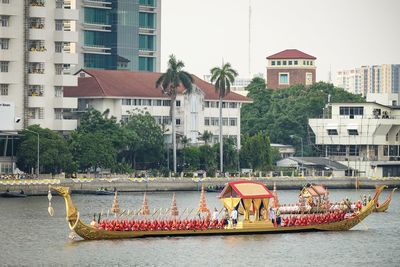 Boats in river by buildings in city