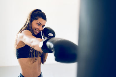 Smiling young woman boxing 