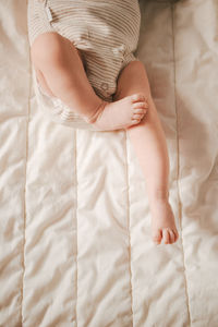 Soft focus close-up of newborn baby feet on a white blanket.