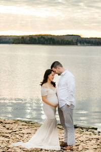 Rear view of couple on beach against sky