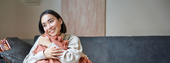 Portrait of young woman sitting at home