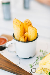 Close-up of french fries in cup on table