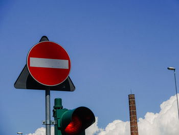 Close-up of road sign against blue sky