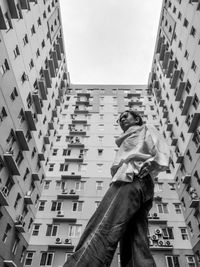 Low angle view of man against building in city against sky