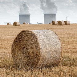 Hay bales on field against sky