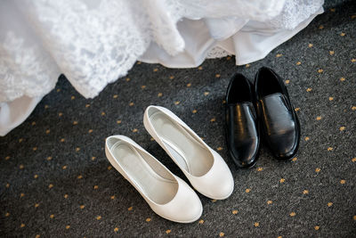 High angle view of shoes on carpet by wedding dress