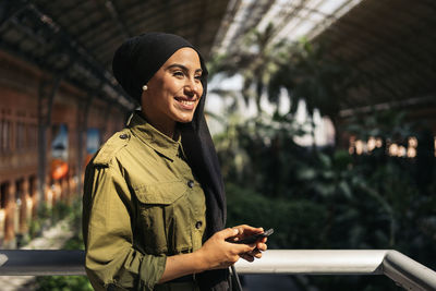 Portrait of modern muslim woman using her smartphone on a train station