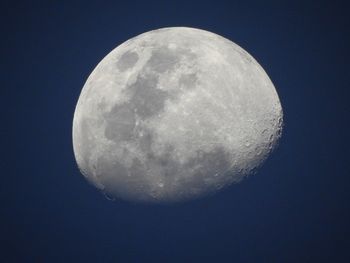 Low angle view of half moon against clear blue sky