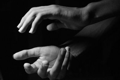 Close-up of father with hand against black background