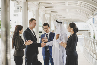 Business people standing on footbridge in city