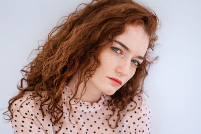 Portrait of serious young woman over white background