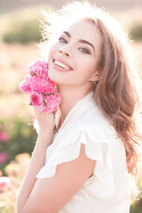 Portrait of smiling young woman standing at farm