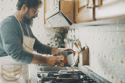 Side view of man working in kitchen