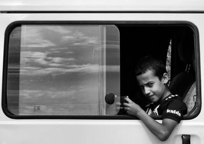 Portrait of boy looking through window