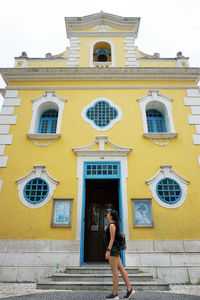 Full length of woman standing against building