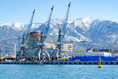 Scenic view of sea by snowcapped mountains against sky