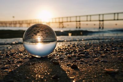 Close-up of crystal ball on beach