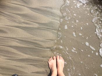 Low section of person on sand at beach