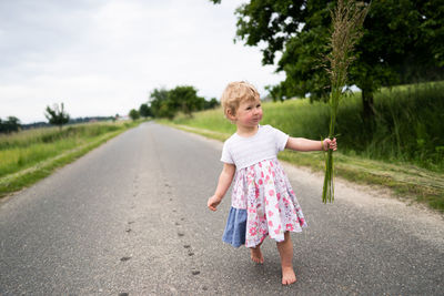 Girl on road against sky