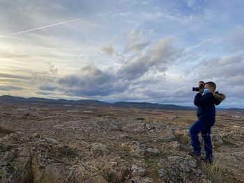 Boy photographing the sunset in a rural setting