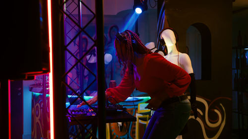 Rear view of woman standing in city at night