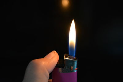 Close-up of hand holding candle