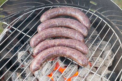 Close-up of sausages being cooked on coal fire