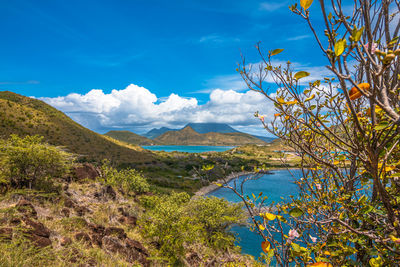 Scenic view of sea and mountains against blue sky