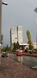 Street by buildings in city against sky