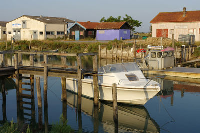 Boats moored in lake against buildings in city