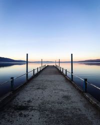 Pier over sea against sky during sunset