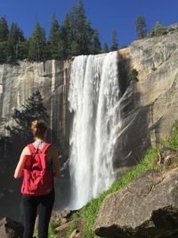 Rear view of woman looking at waterfall