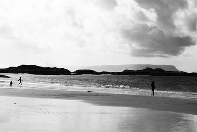 People walking on beach against sky
