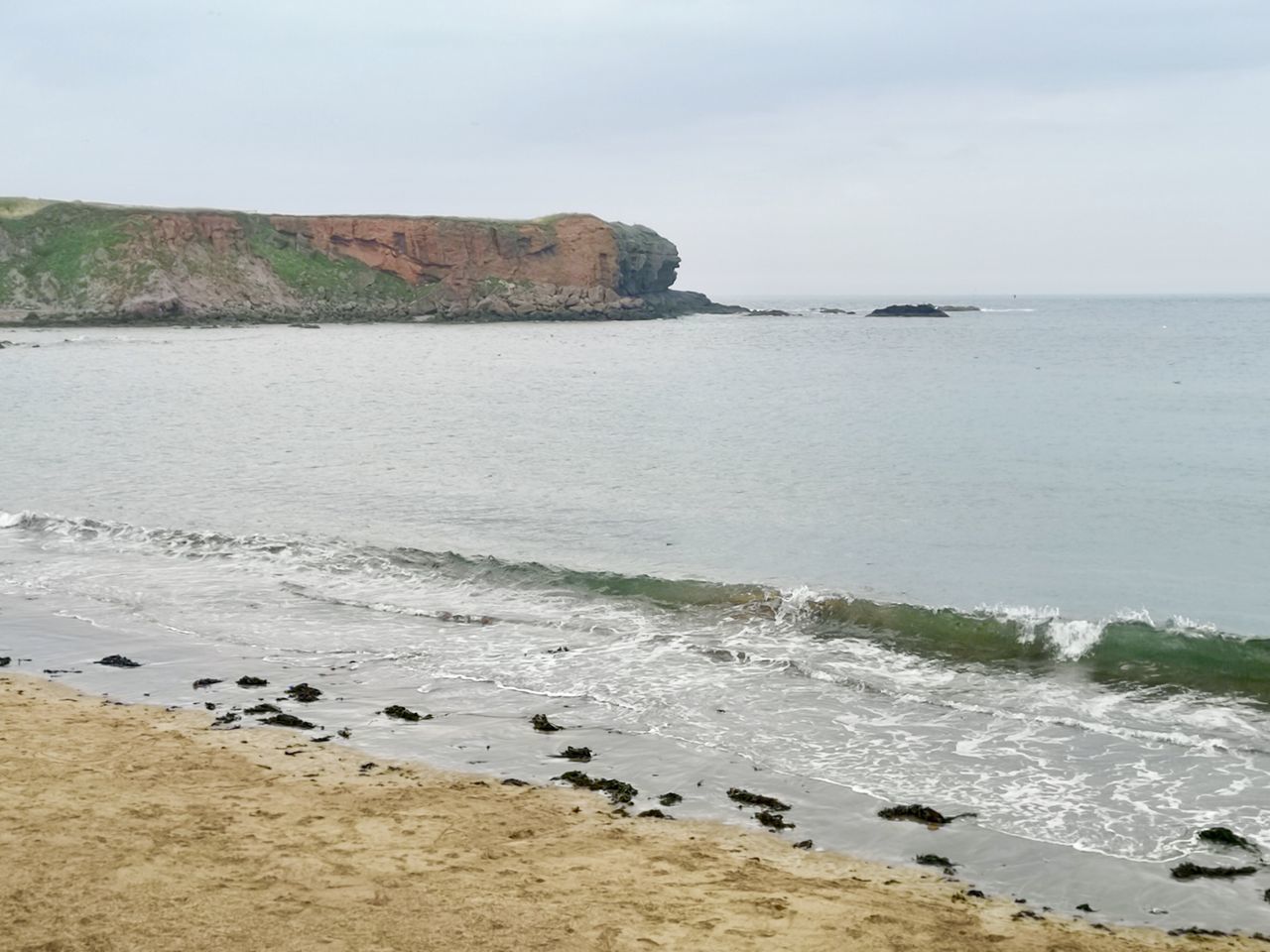 ROCKS BY SEA AGAINST SKY