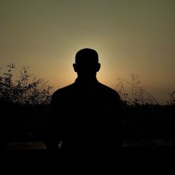 Silhouette man standing against sky during sunset