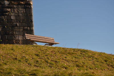 Low angle view of built structure on field against clear sky