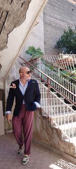 Businessman wearing sunglasses standing by staircase