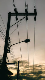 Low angle view of silhouette birds on pole against sky