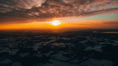 Aerial view of landscape against dramatic sky during sunset