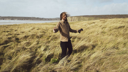 Full length of woman standing on land against sky