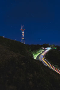 Light trails on road against sky at night