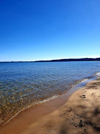 Scenic view of sea against clear blue sky