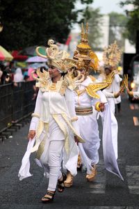 People in traditional clothing walking on road