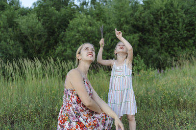 Smiling girl with mother on field